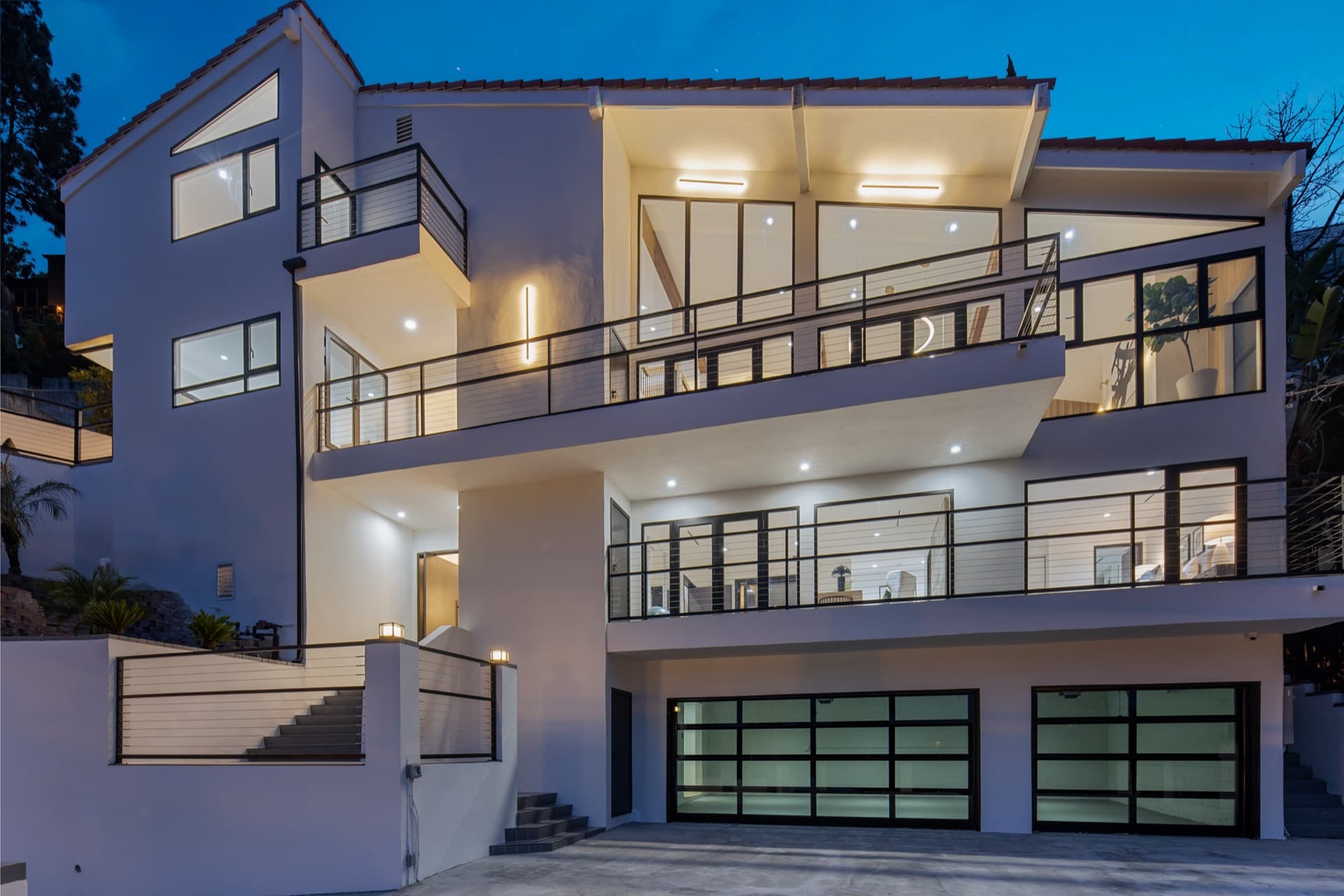 Claremont Residence at night — three stories of illuminated glazing