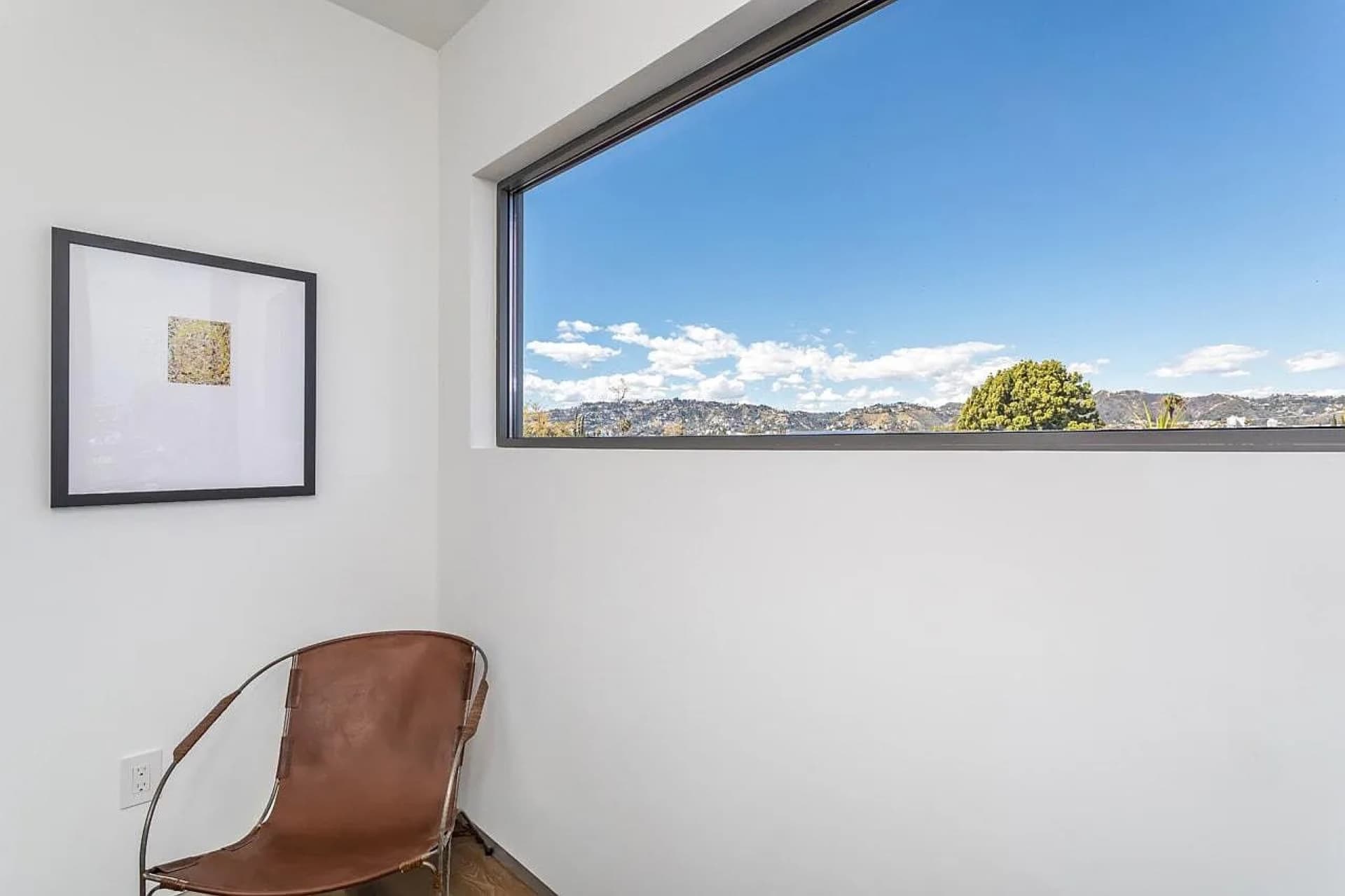 Picture window framing the hillside view